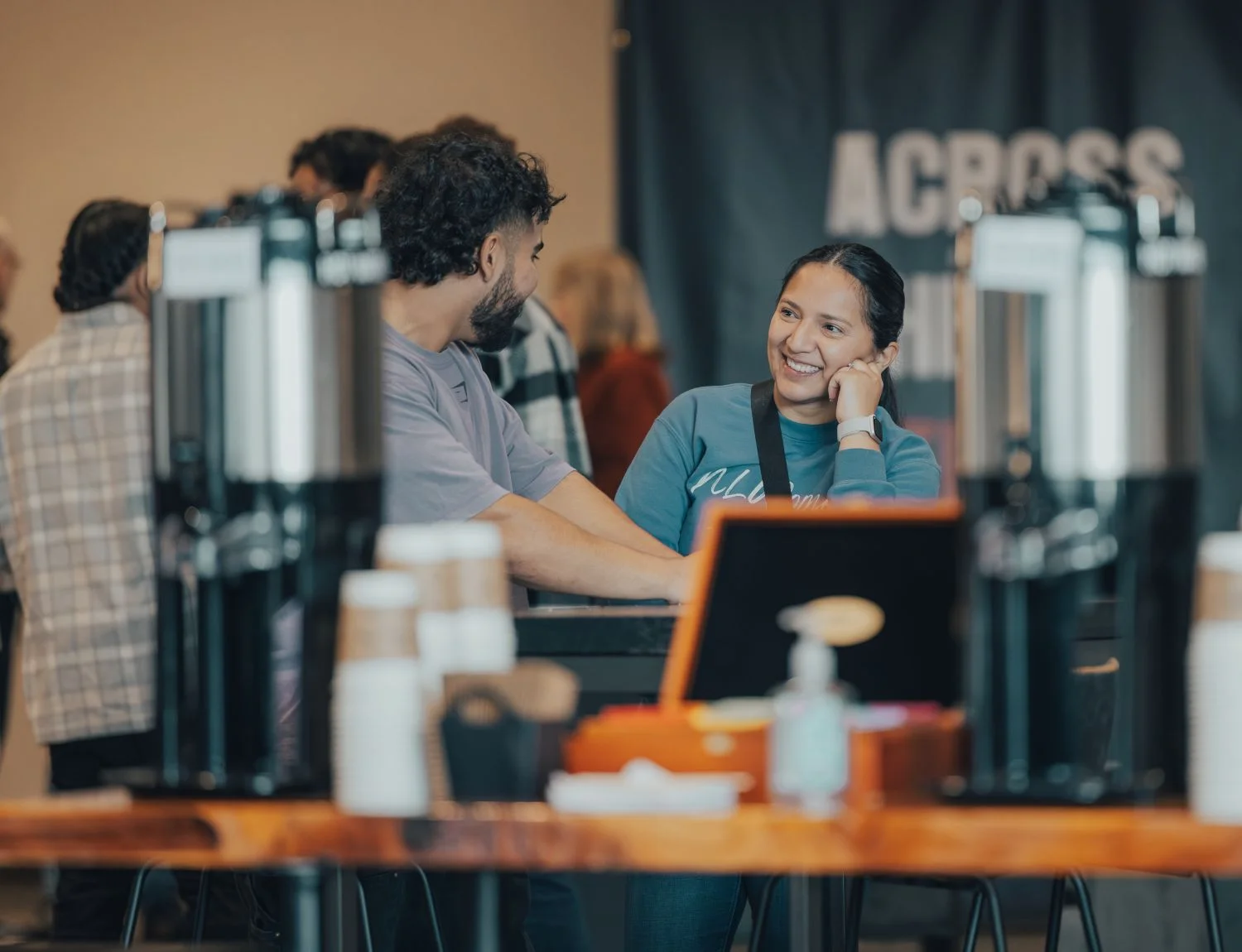 Smiling barista interacting with customer at coffee shop counter