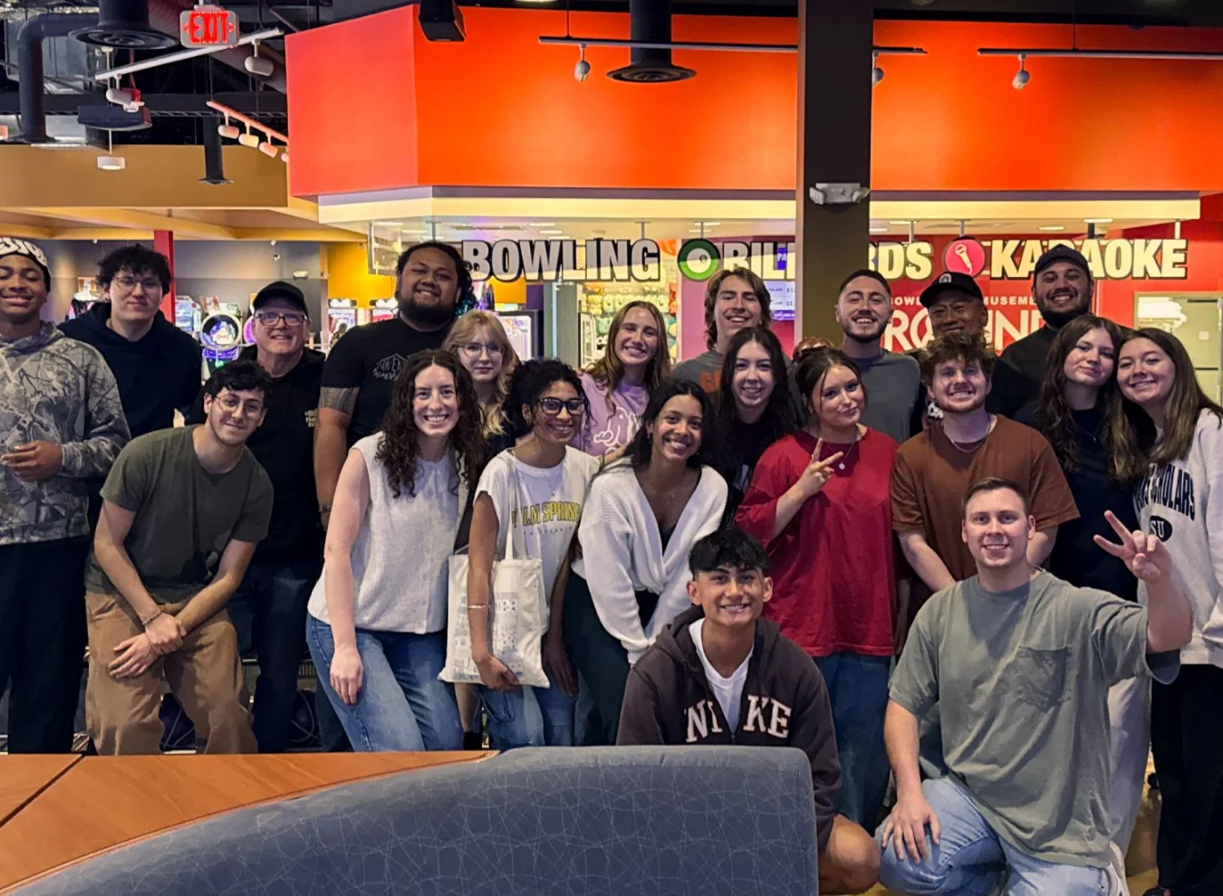 Large group of young people posing together at a bowling alley