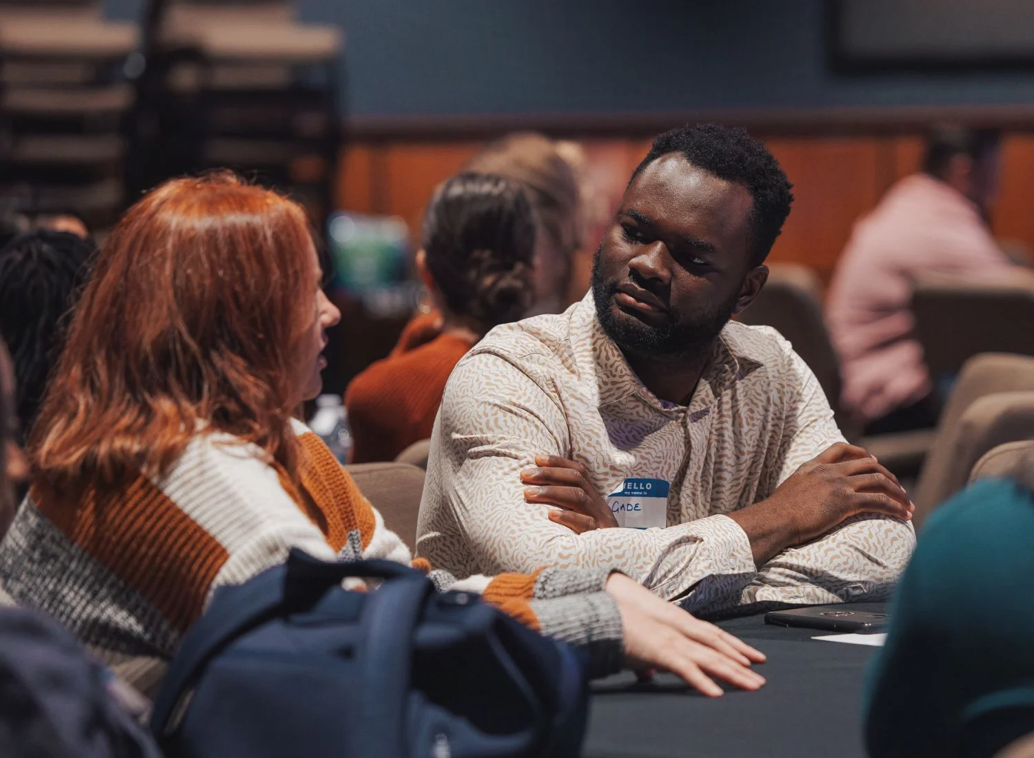 Two people in knit sweaters having an intense conversation at a conference