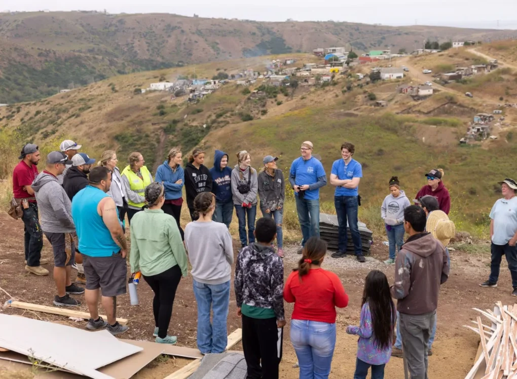 Group of volunteers gathered on hillside for community construction project