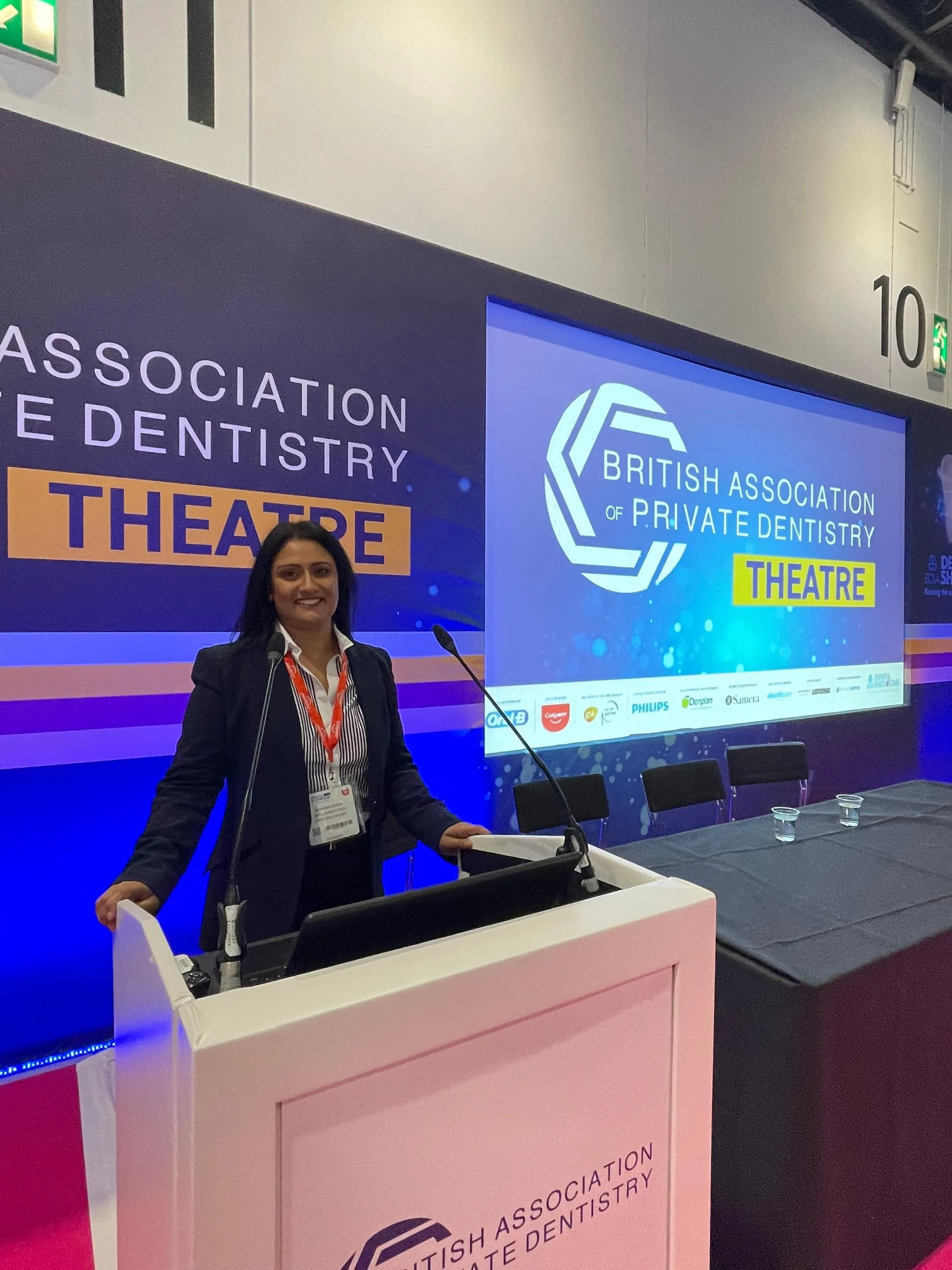 Woman standing at a podium in the British Association of Private Dentistry Theatre