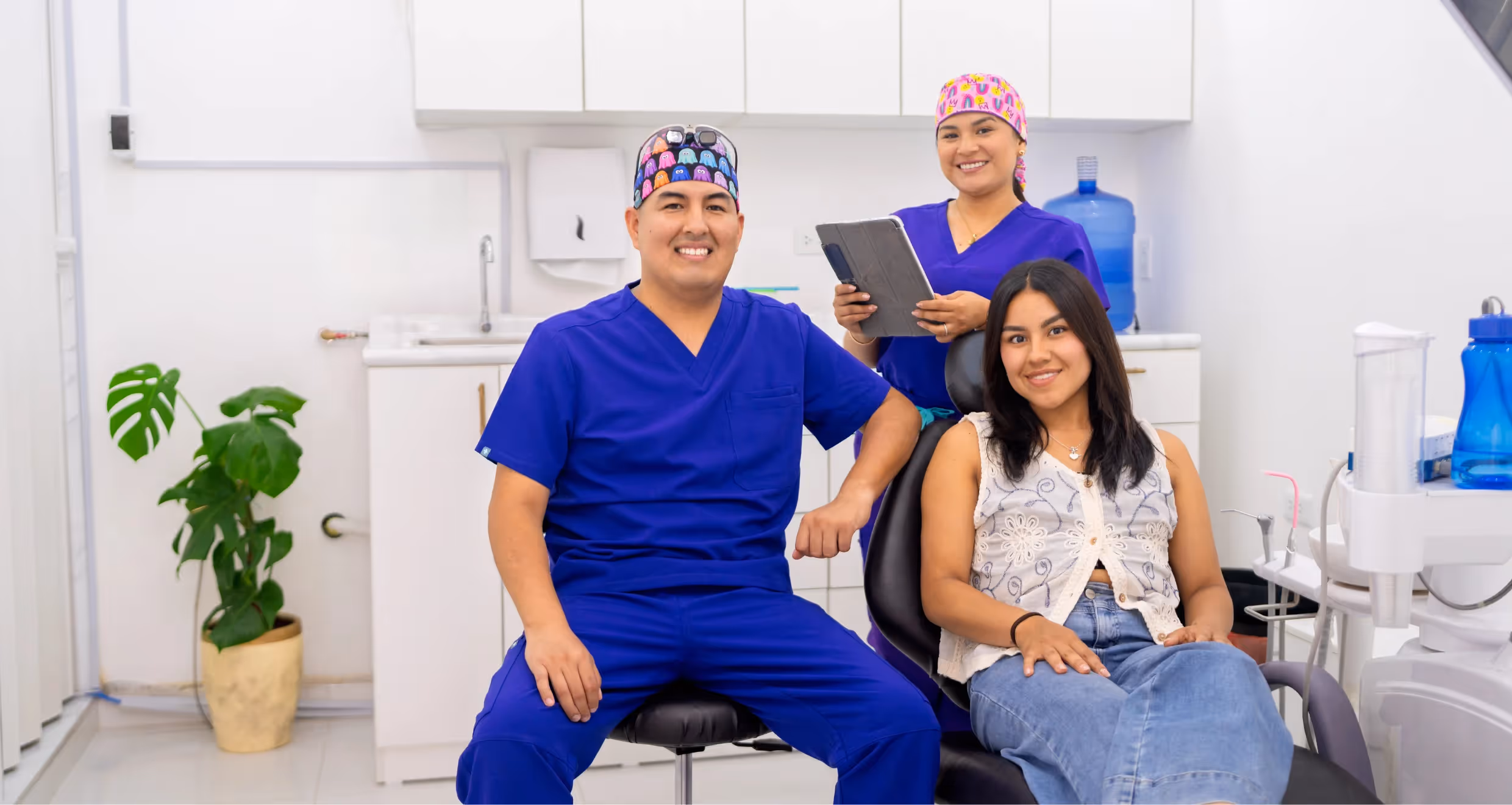 two smiling dentists with a smiling patient