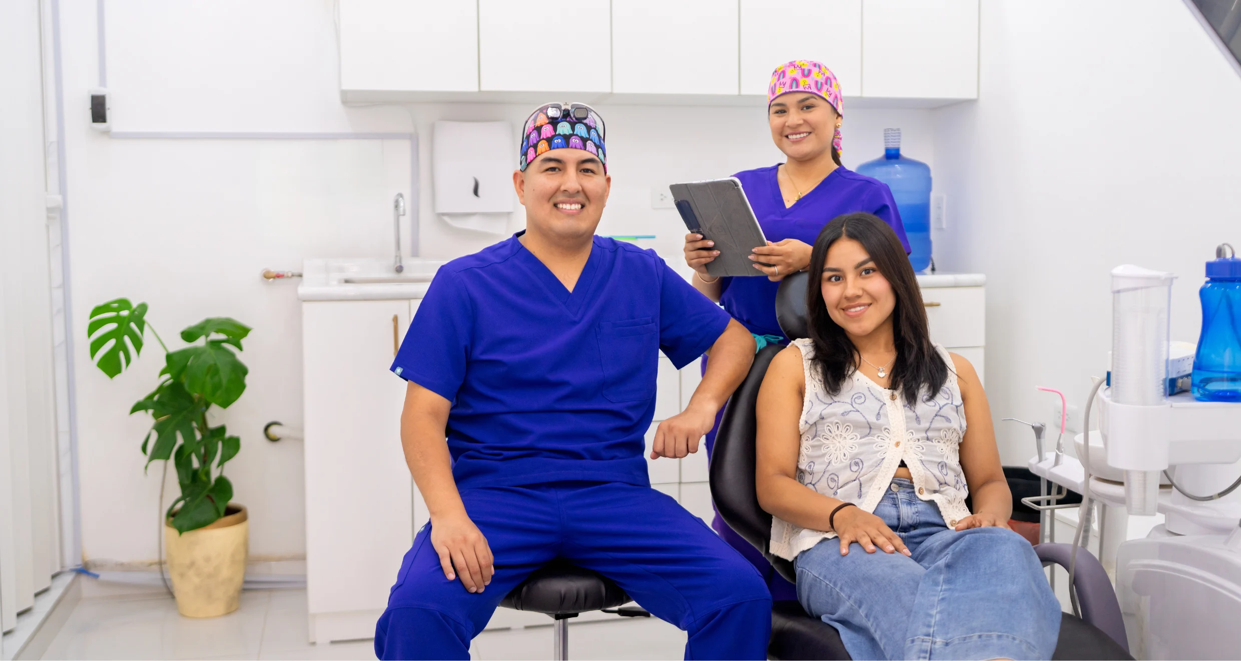 two smiling dentists with a smiling patient