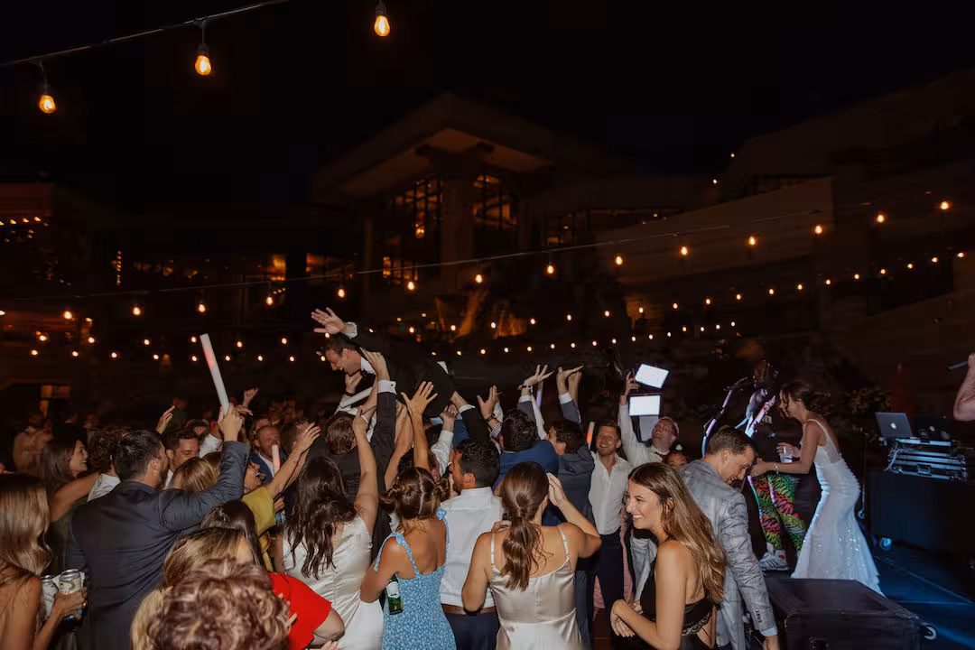 wedding groom being lifted by wedding guests on dance floor