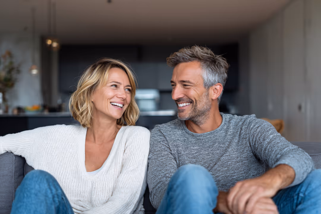 Couple smiling at each other in living room