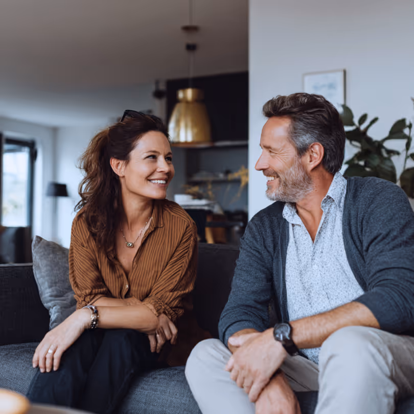 Couple smiling at each other on a couch