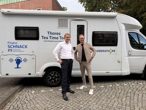 Thore Ziebell mit einem Podcastgast vor einem Wohnmobil