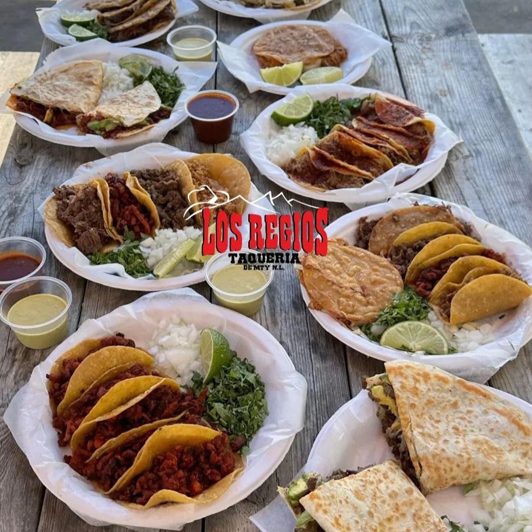 A table full of food with a sign that says Los Regios.