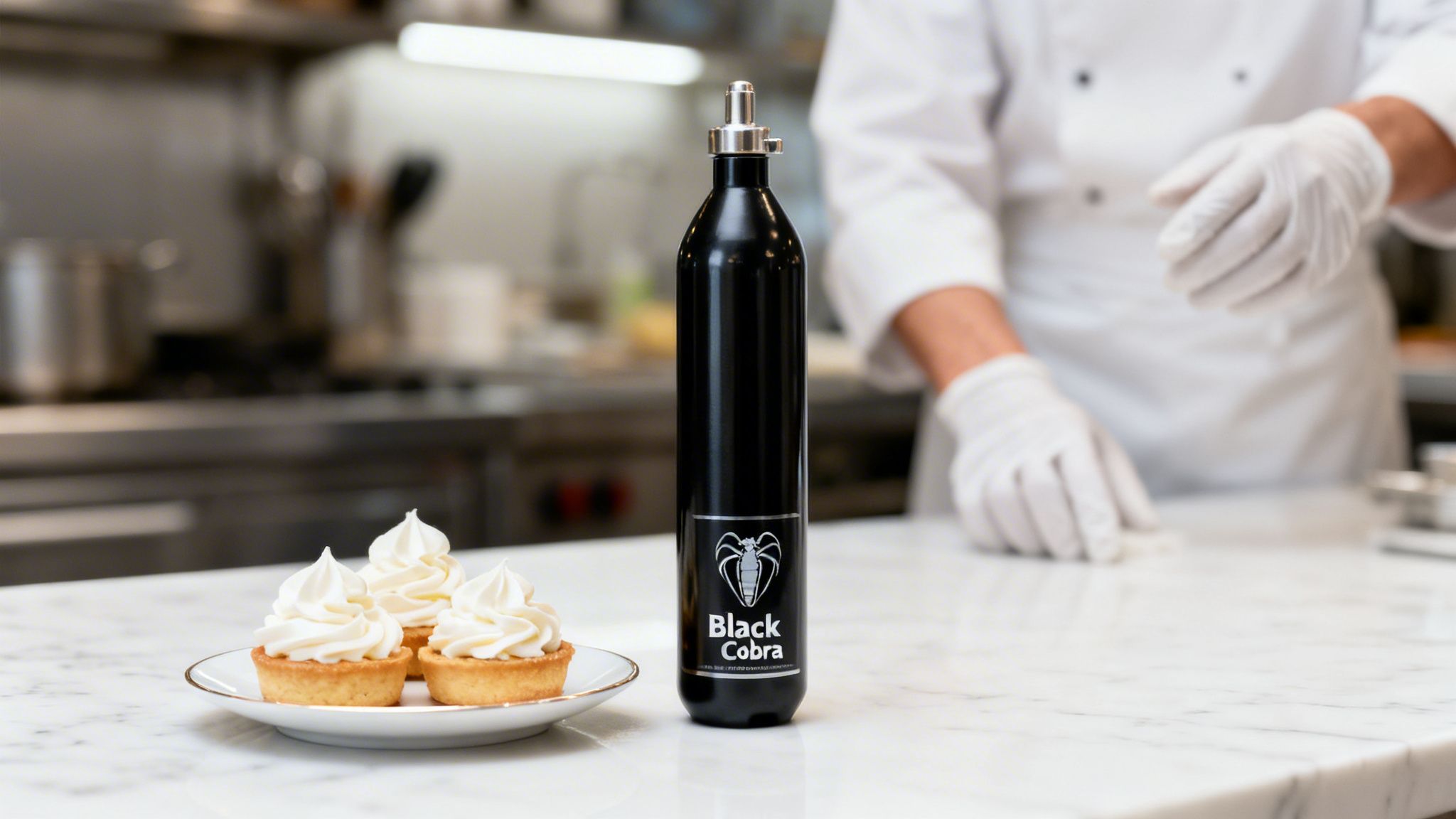 A black Black Cobra nitrous oxide bottle stands beside cream tarts on a kitchen counter.