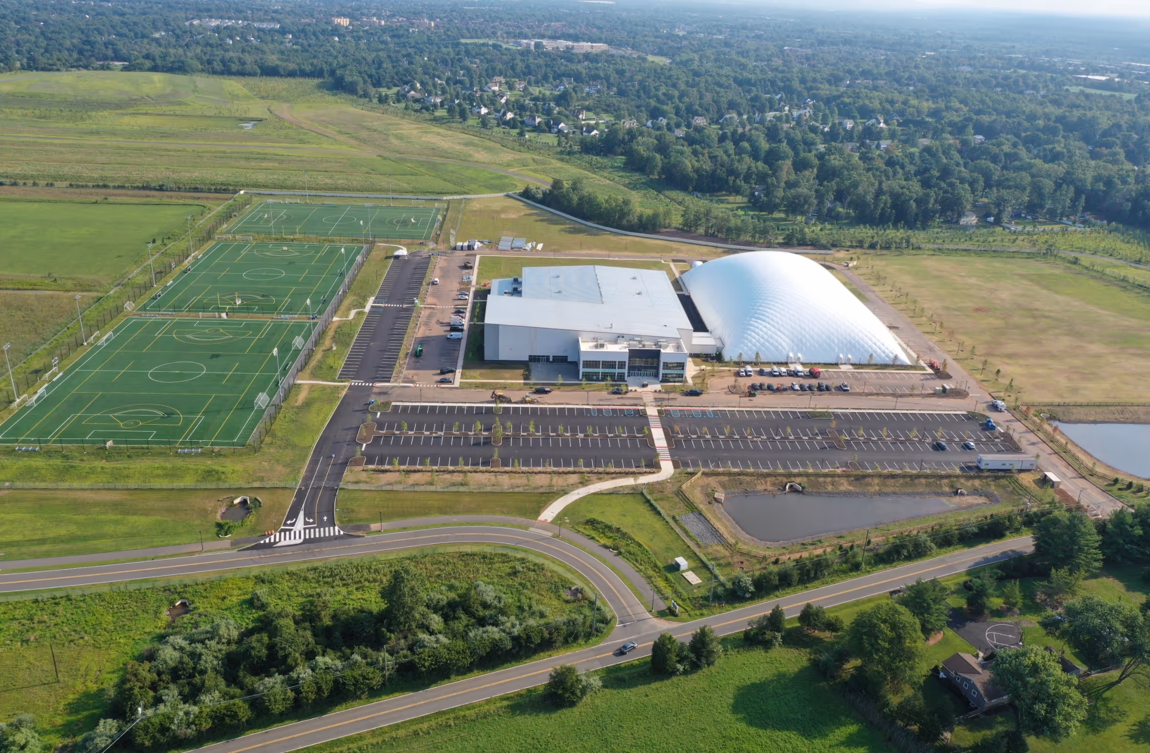 A birdseye view of Iron Peak Sports and Events Complex in Hillsborough New Jersey - showing a building, air bubble and three outdoor soccer fields.