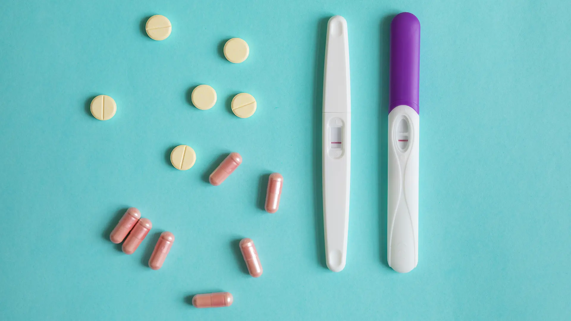 Vruchtbaarheid verbeteren met voeding, supplementen en gezonde leefstijl – zwangerschapstest en vitamines op blauwe achtergrond.