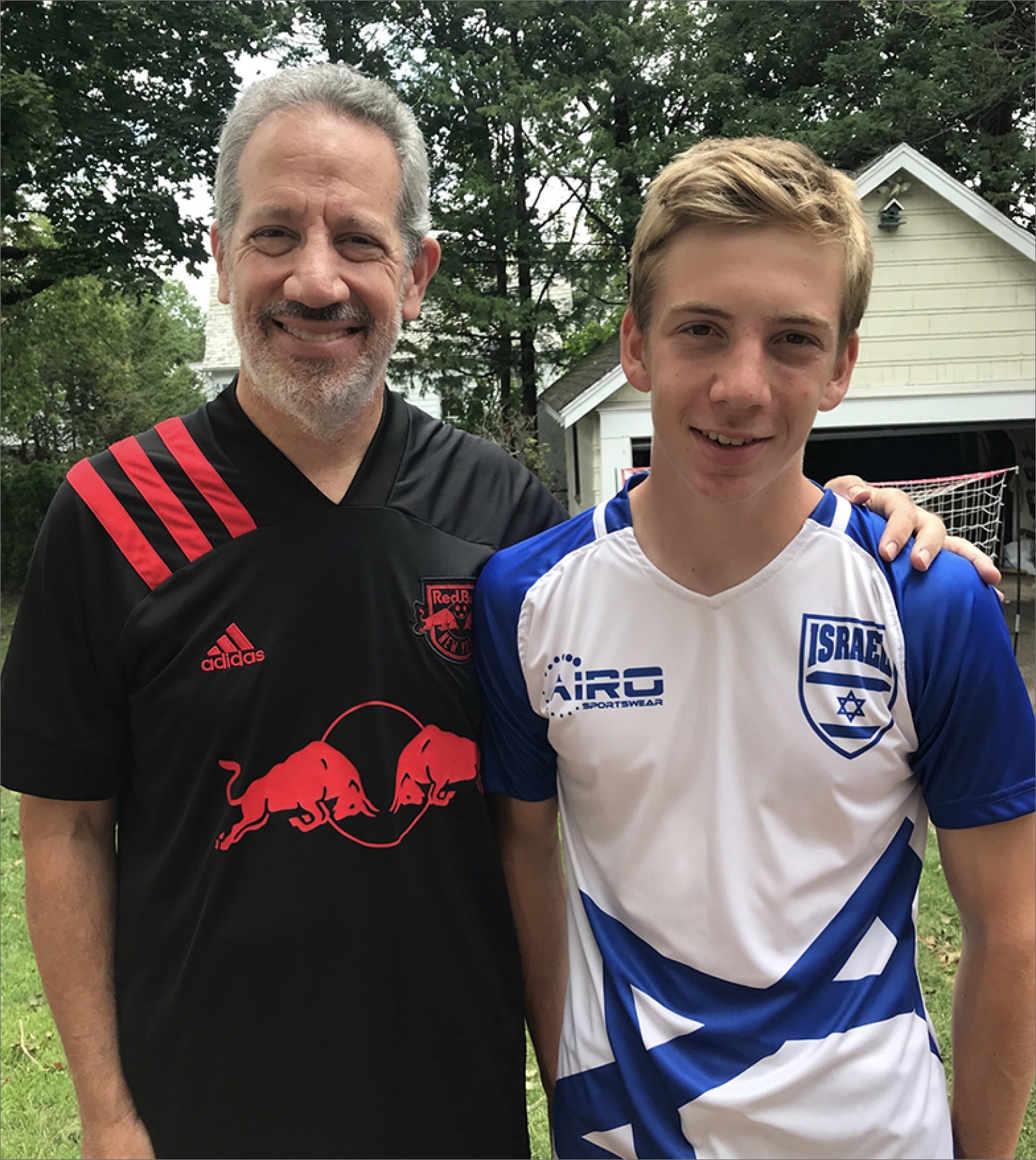 An FLI father and son smiling in the yard