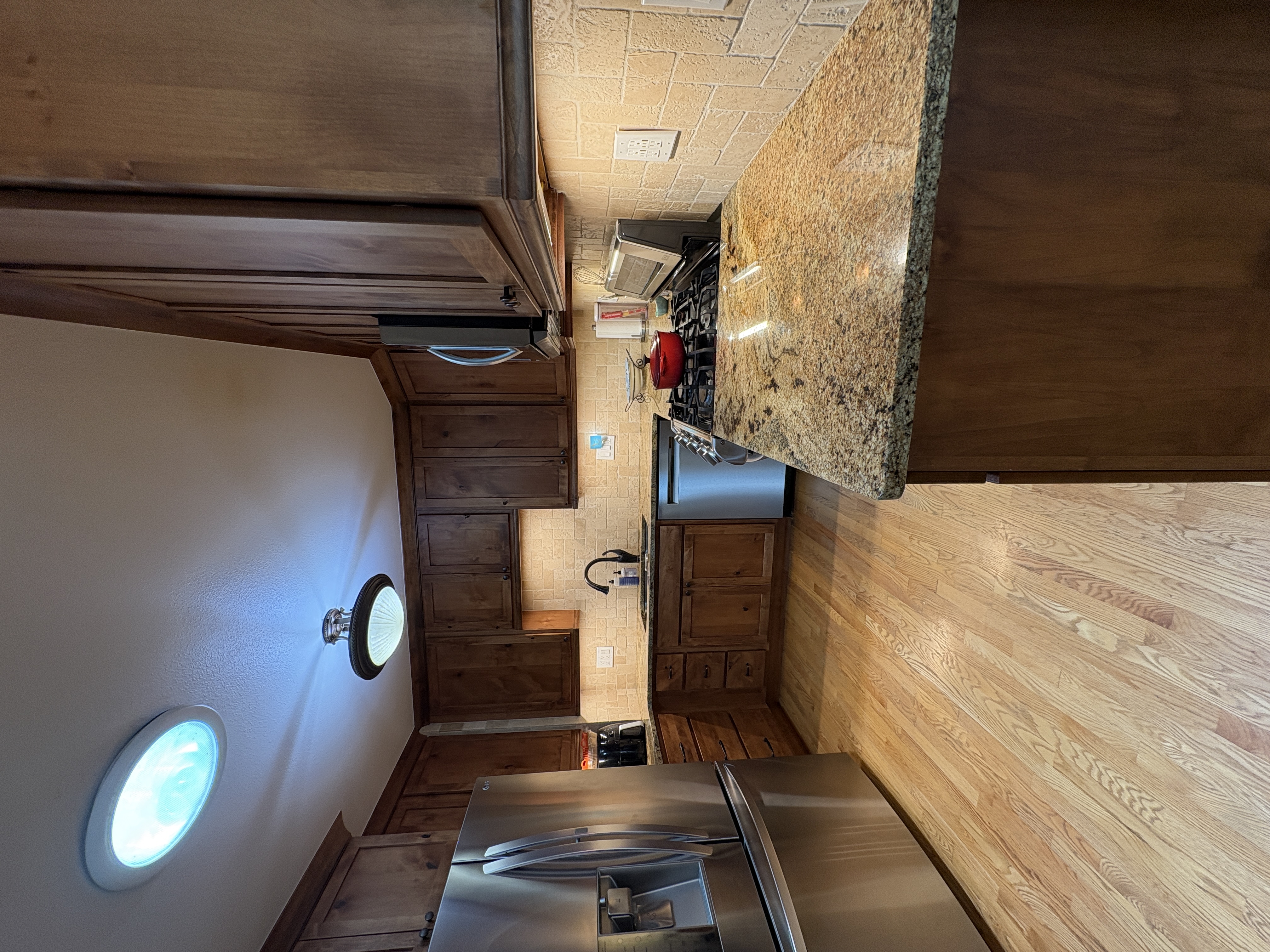 Kitchen renovation featuring granite countertops dark, dark wood finish cabinets, and wood flooring