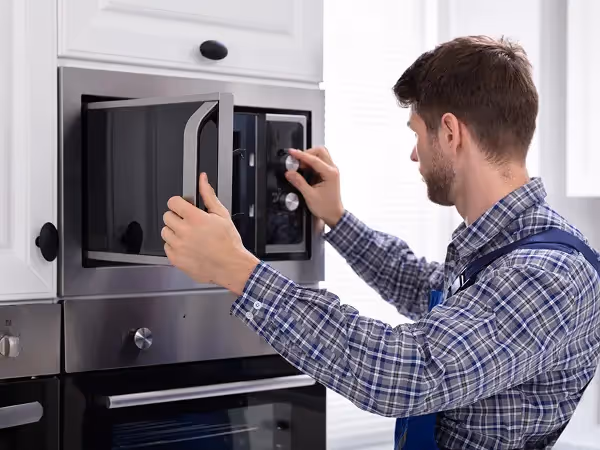 technician repairing a microwave