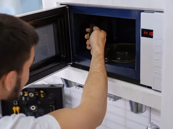technician repairing a microwave