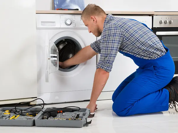 technician in a process of repairing a washer