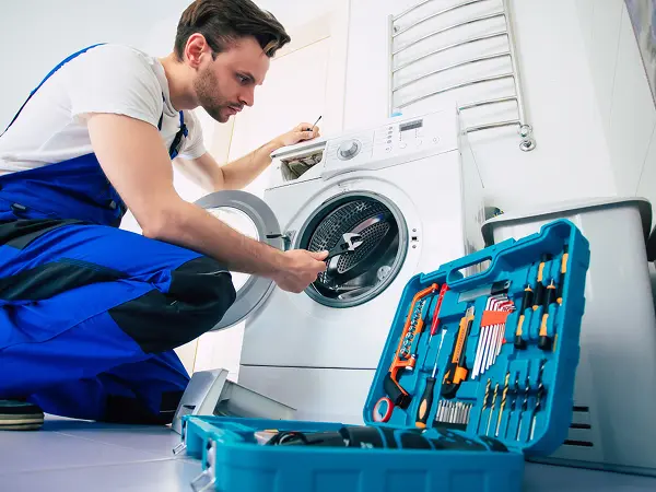 technician repairing a washer