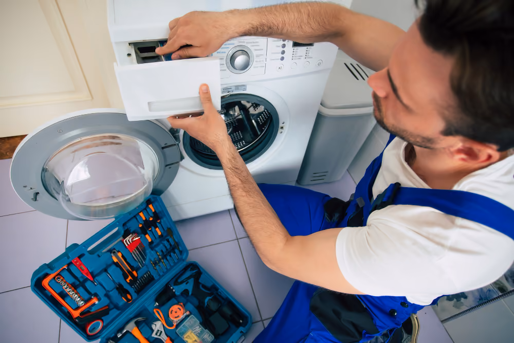 repairman in worker suit with the professional tools box is fixing samsung washer