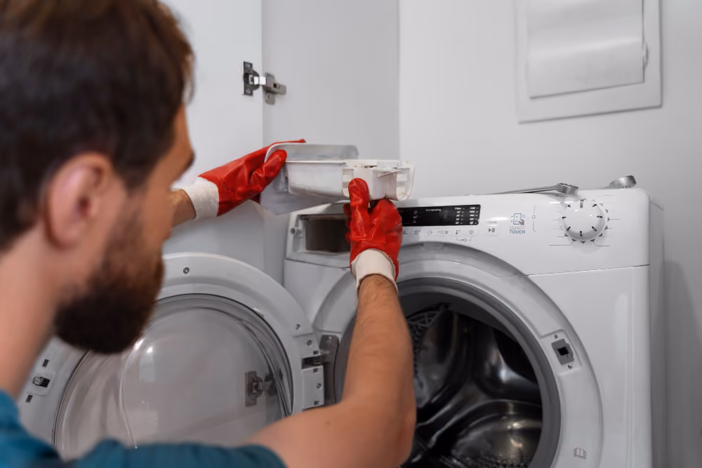 Technician removing detergent drawer from a Bosch front-load washing machine during repair