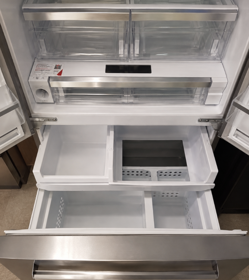 Open Frigidaire French-door refrigerator showing interior drawers and freezer compartment