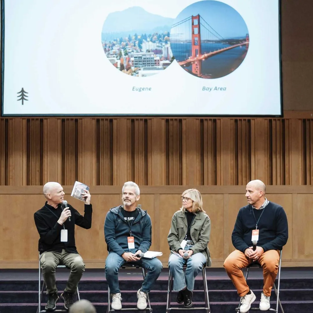 Kevin Palau speaking on stage in a panel of three other people