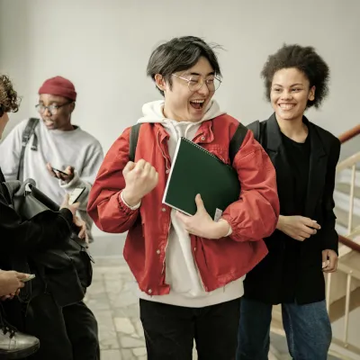 Students feeling confident after practicing mock exams on a study app, walking together with smiles.