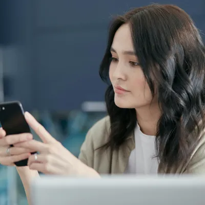 Student using a smartphone for instant translations while preparing for massage therapy certification.