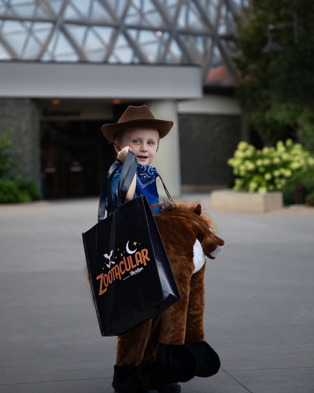 image of child dressed up in cowboy costume, holding Zootacular treat bag