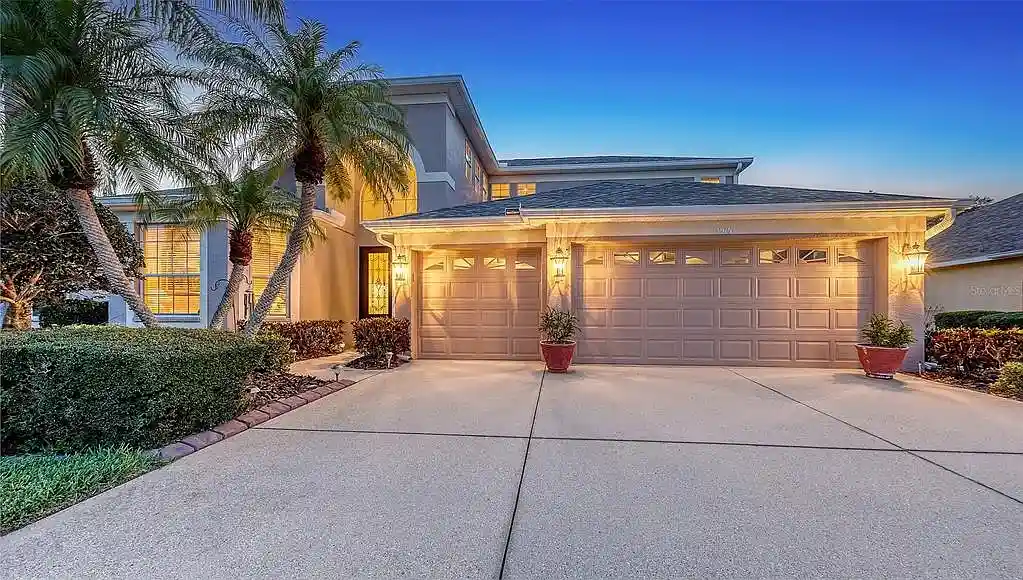 Exterior house painting project in Sarasota with fresh paint, palm trees, and driveway lighting