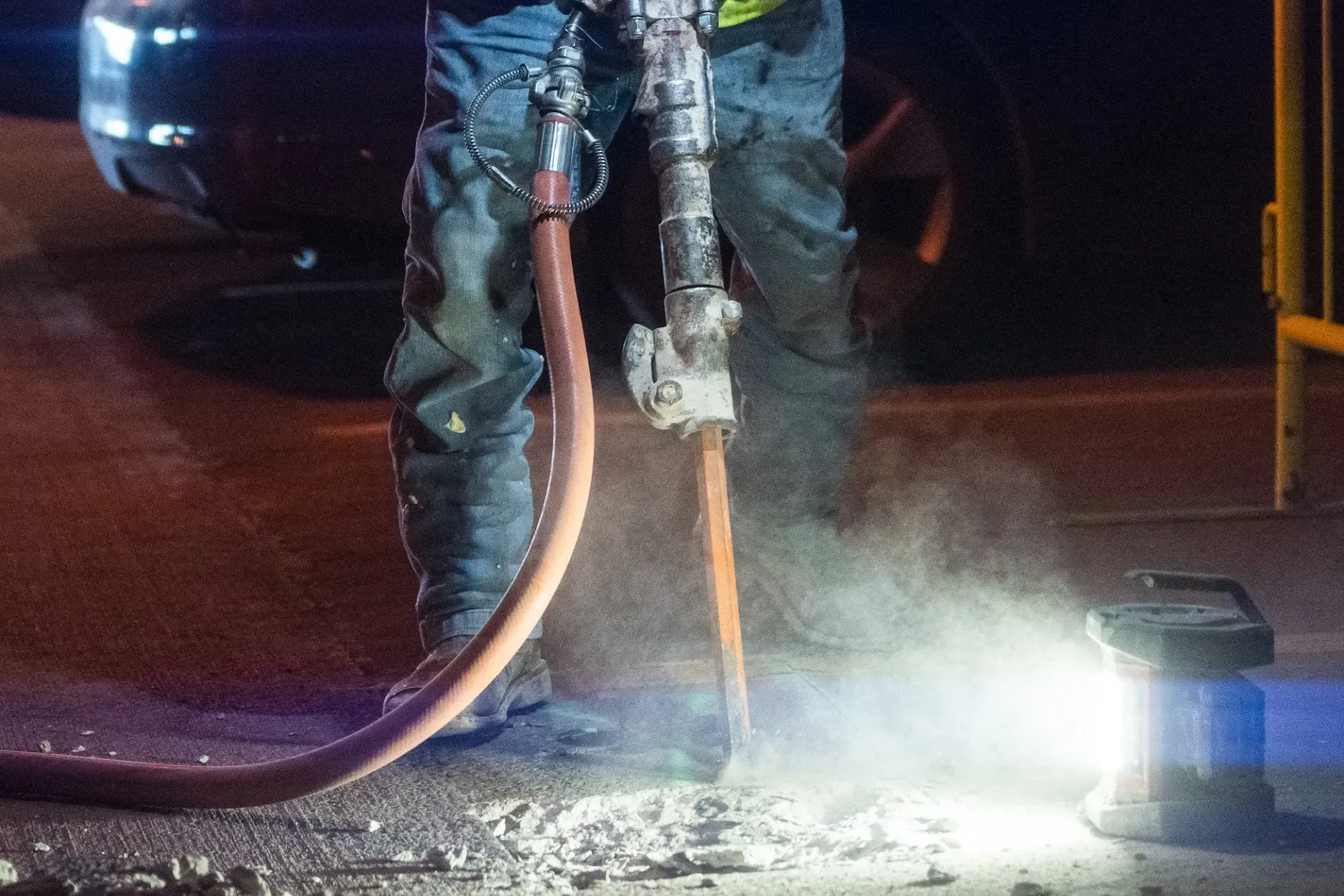 A Gerber crew member jackhammers damaged concrete at night, the hard, messy work restoration takes.