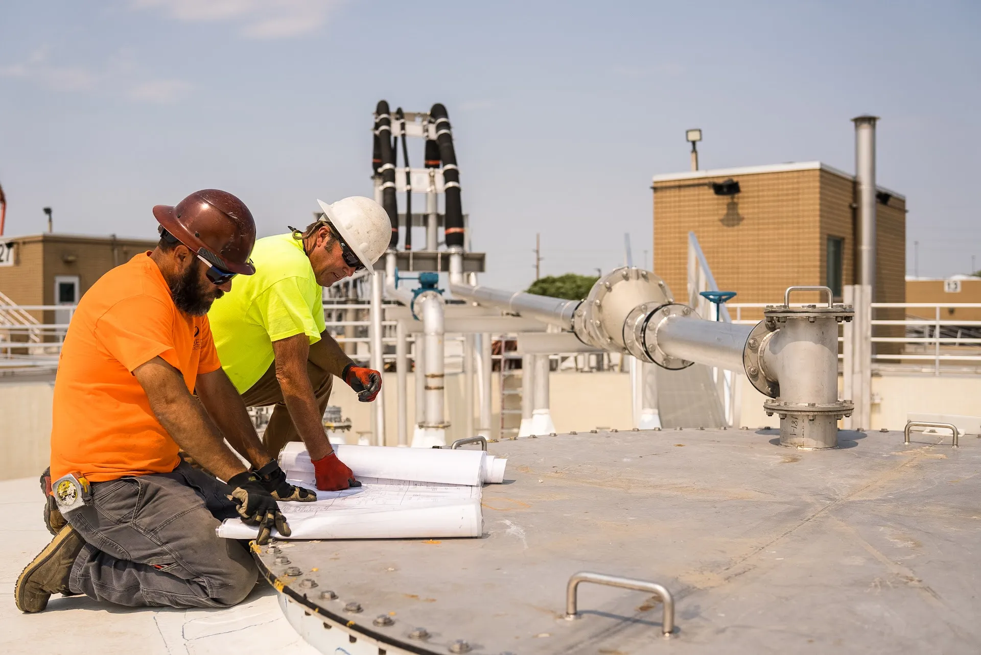Two Gerber crew members kneel on a concrete deck and review the plans together before work begins.