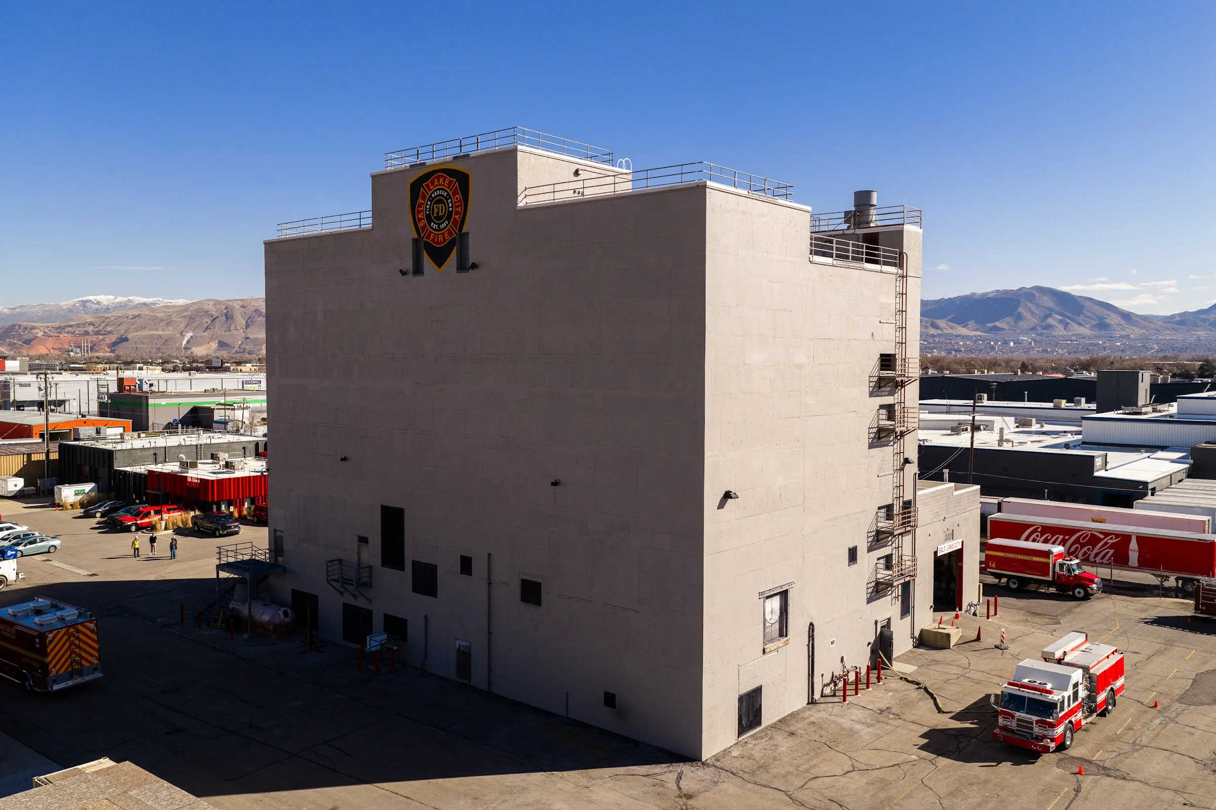 A restored fire station training tower with fire trucks parked beside it.