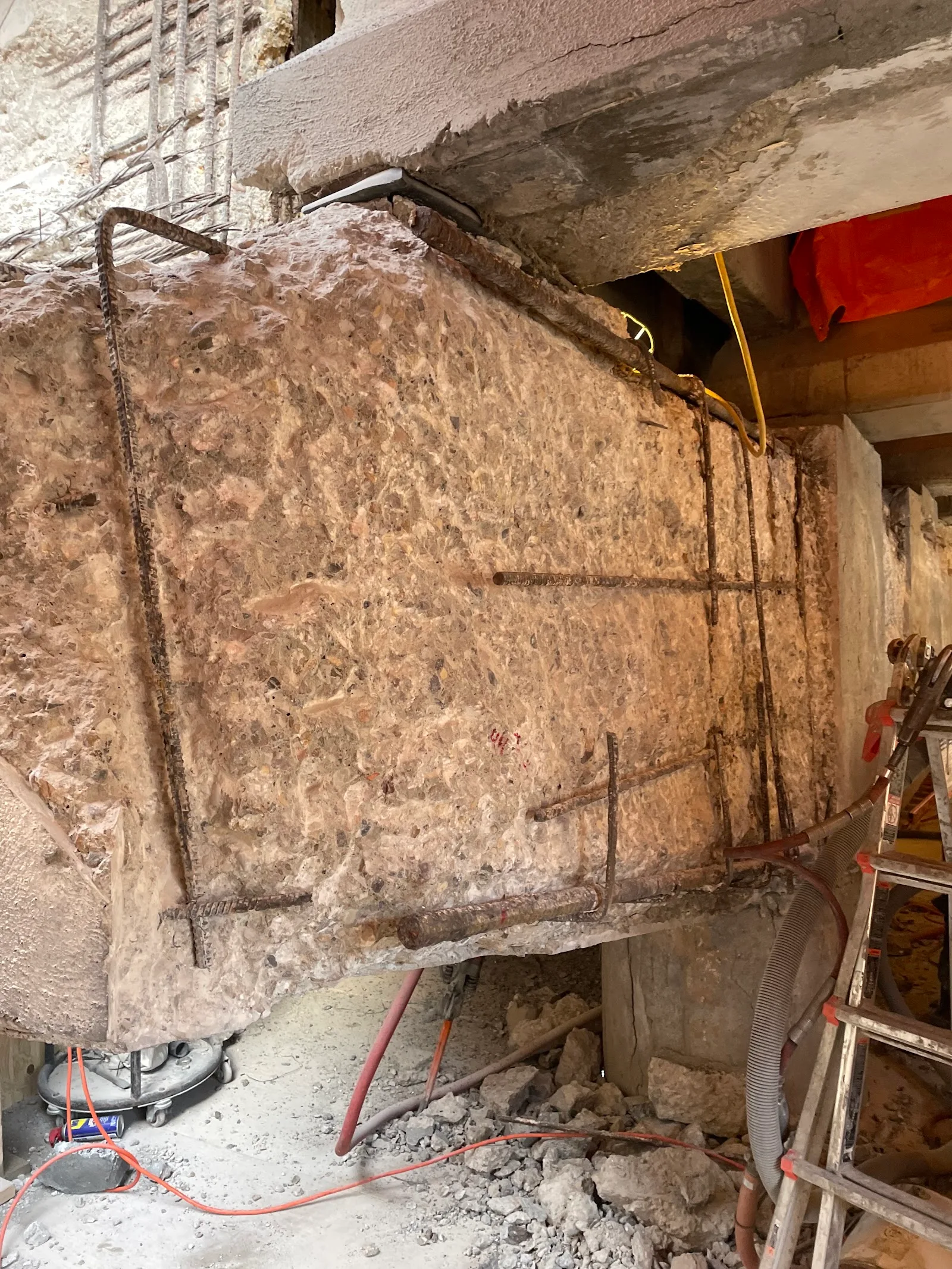 A bridge pier cap chipped back to sound concrete, exposing rusted rebar that could not be seen from the surface.