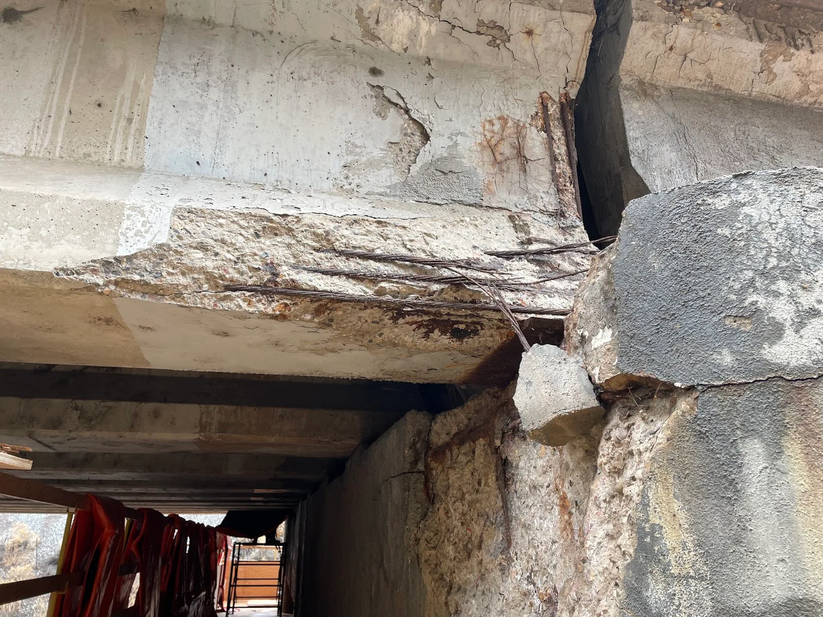 Before: a bridge beam end with spalled concrete and broken, rusted reinforcing strands.
