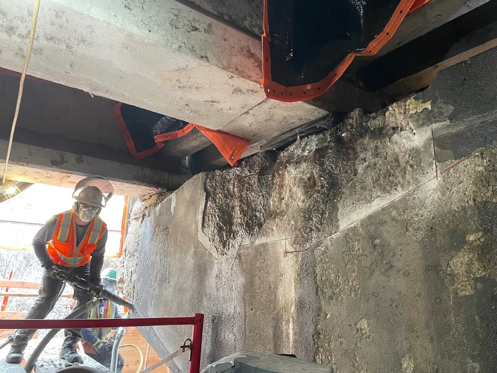 Gerber crew members remove damaged concrete from a bridge pier cap before rebuilding it.
