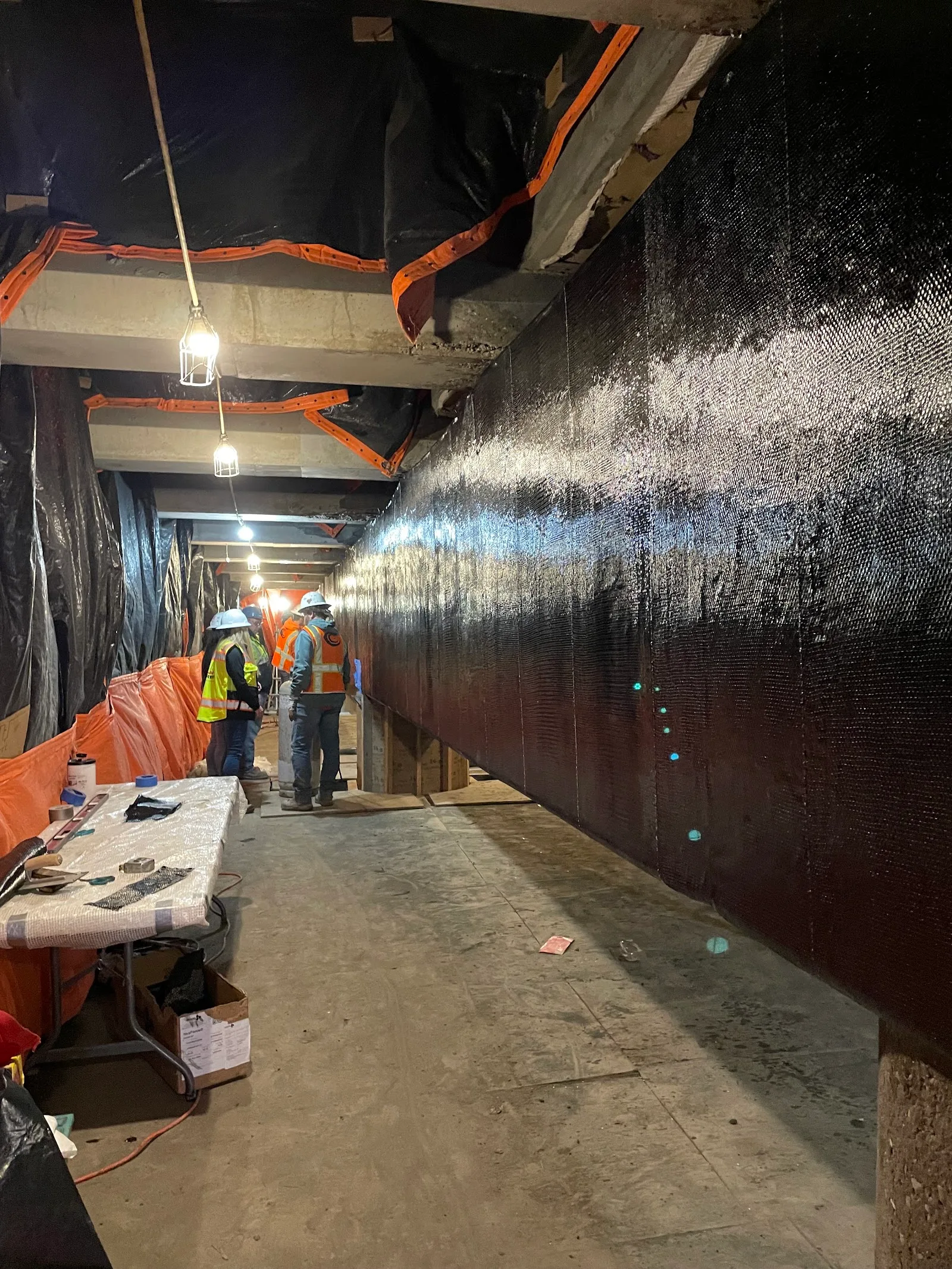 Carbon fiber fabric saturated with resin is pressed onto a repaired bridge beam.