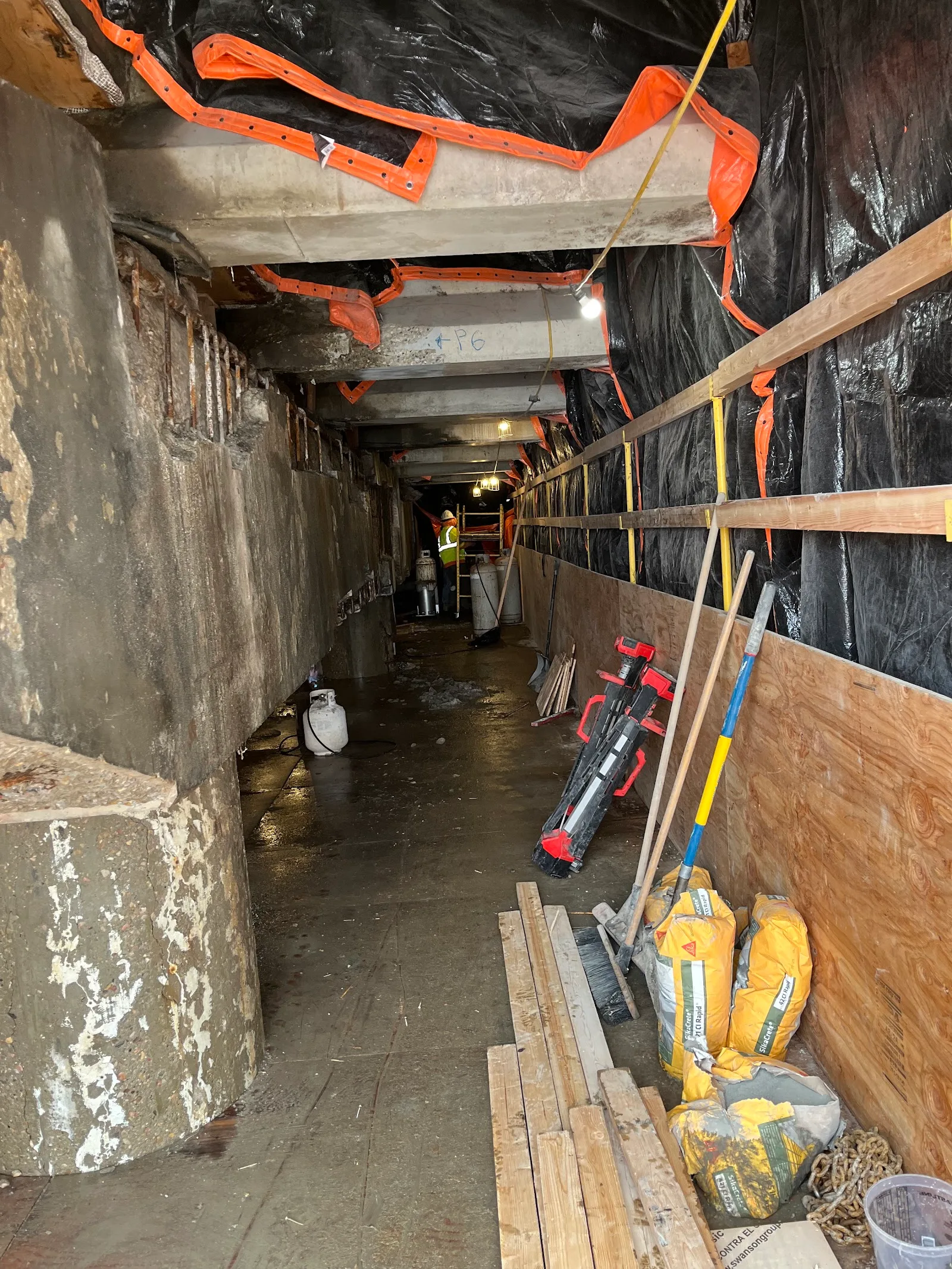A containment work area under a bridge, set up so removed concrete doesn't fall below.