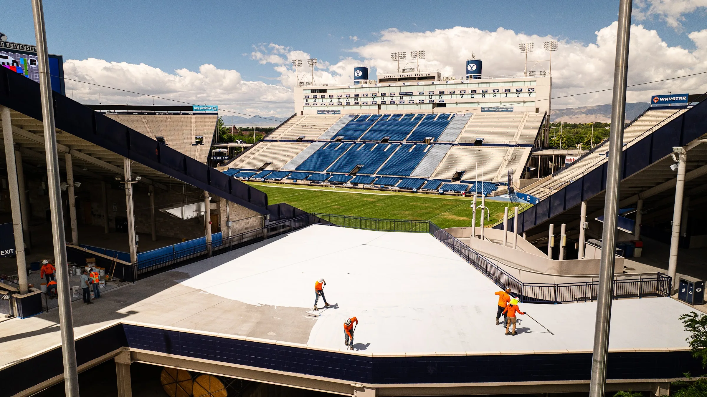 Wide view of freshly coated concourse decks overlooking a stadium field.