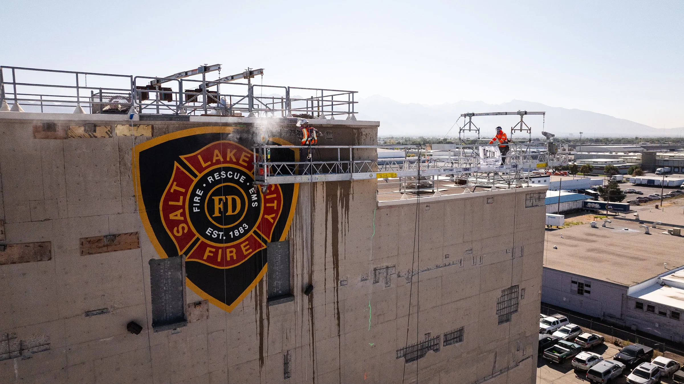 During: a crew member pressure-washes the top of the tower as dirty water streaks down the concrete.