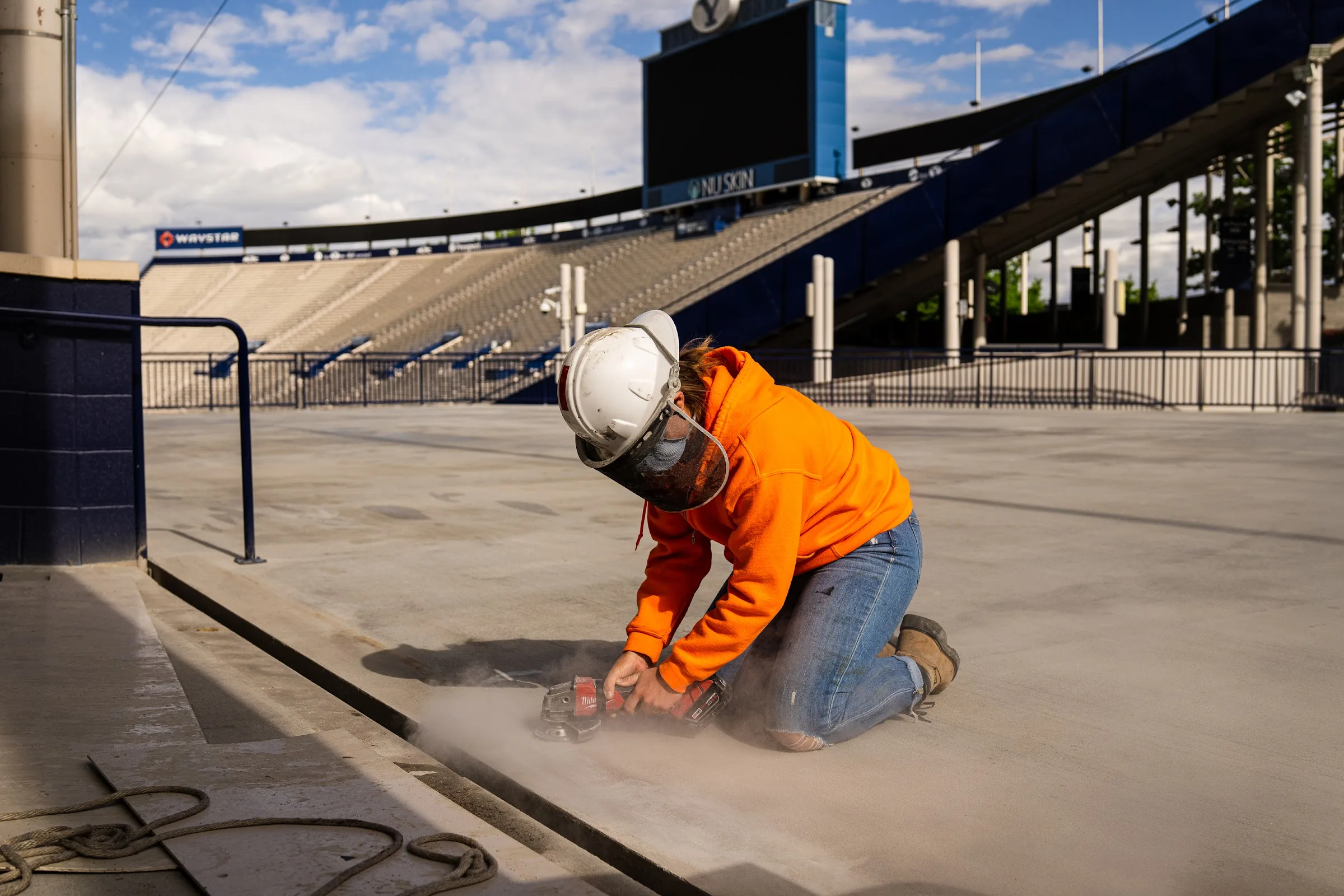 A Gerber crew member grinds the concrete surface of a stadium concourse.