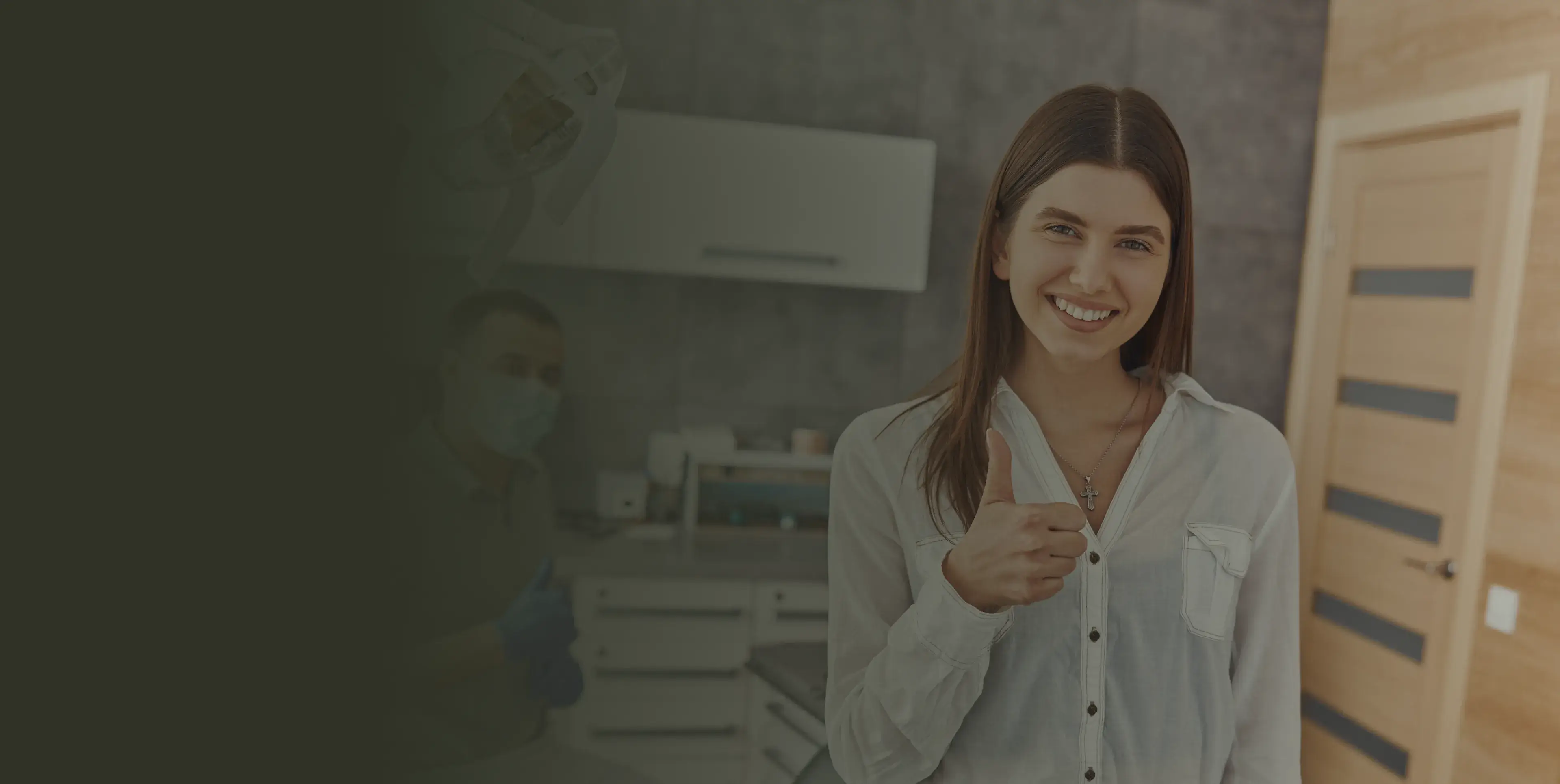 Woman smiling and giving a thumbs-up in a dental office.