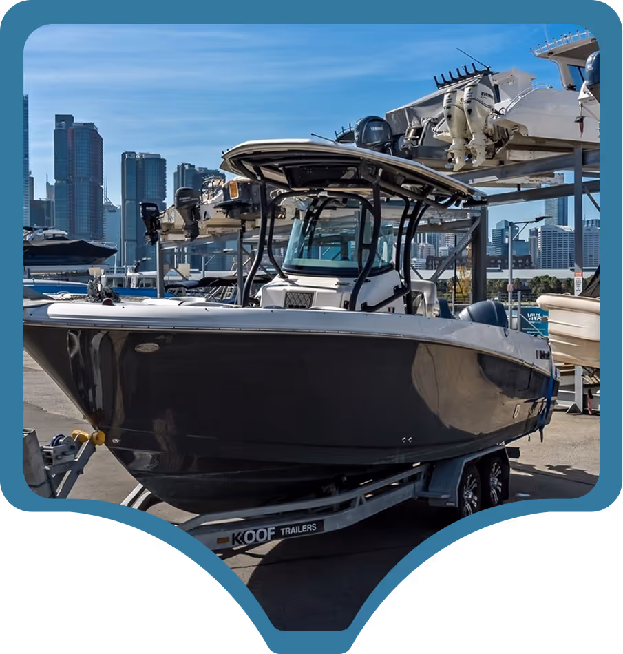 Boat on a trailer in a marina with high-rise cityscape in the background; a sunny day creates a vibrant, adventurous atmosphere.