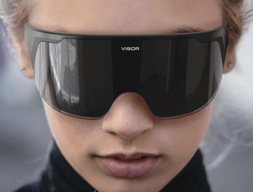 Close-up of a person wearing black futuristic-looking visor glasses with "VISOR" text on the front.