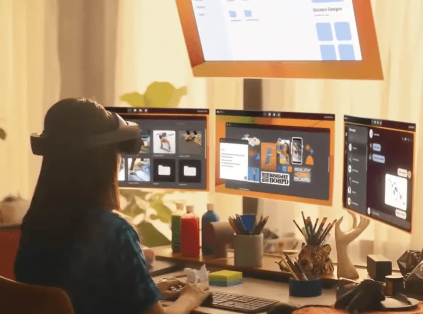 A person wearing a VR headset interacts with multiple floating virtual screens in a bright office environment.