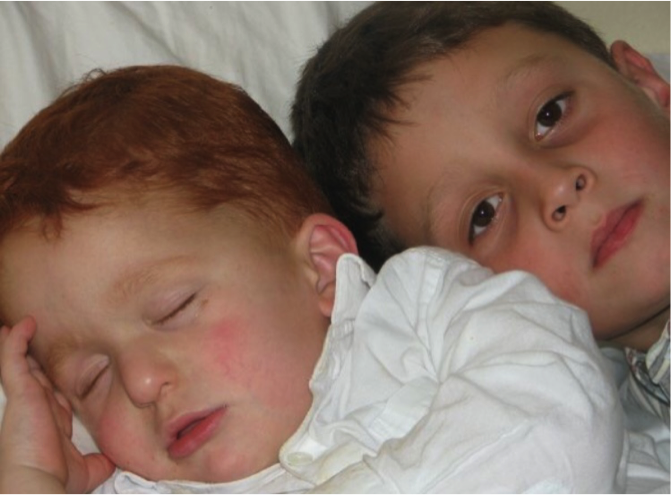 Nate as a toddler, napping alongside his older brother.