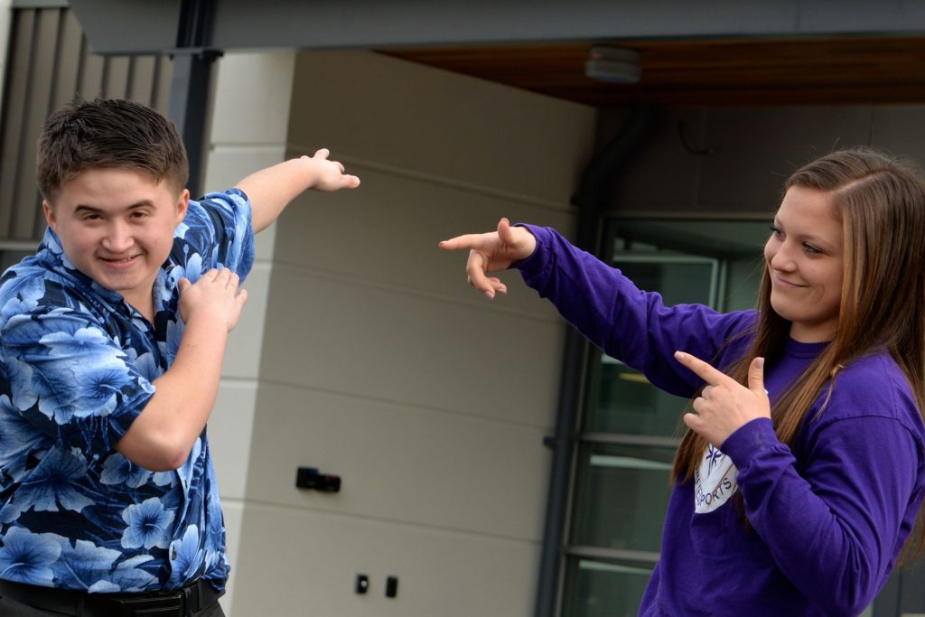 two teens joking around outside a gym
