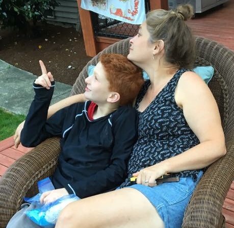 mother and son outside, sitting in a chair together