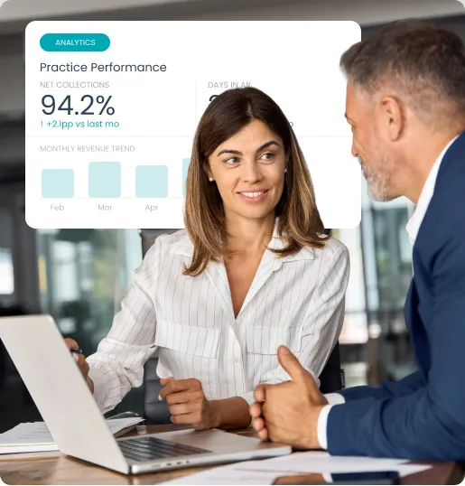 Woman and man in office discussing data shown on laptop with practice performance metrics overlay.