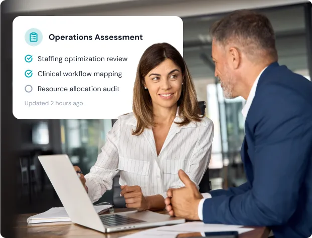 Woman and man discussing operations assessment with laptop and checklist of staffing and workflow items.