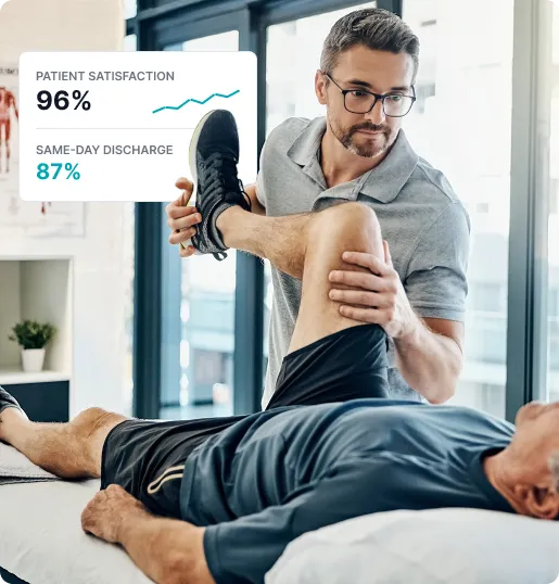 Therapist in glasses assists patient by stretching his leg during physical therapy session.